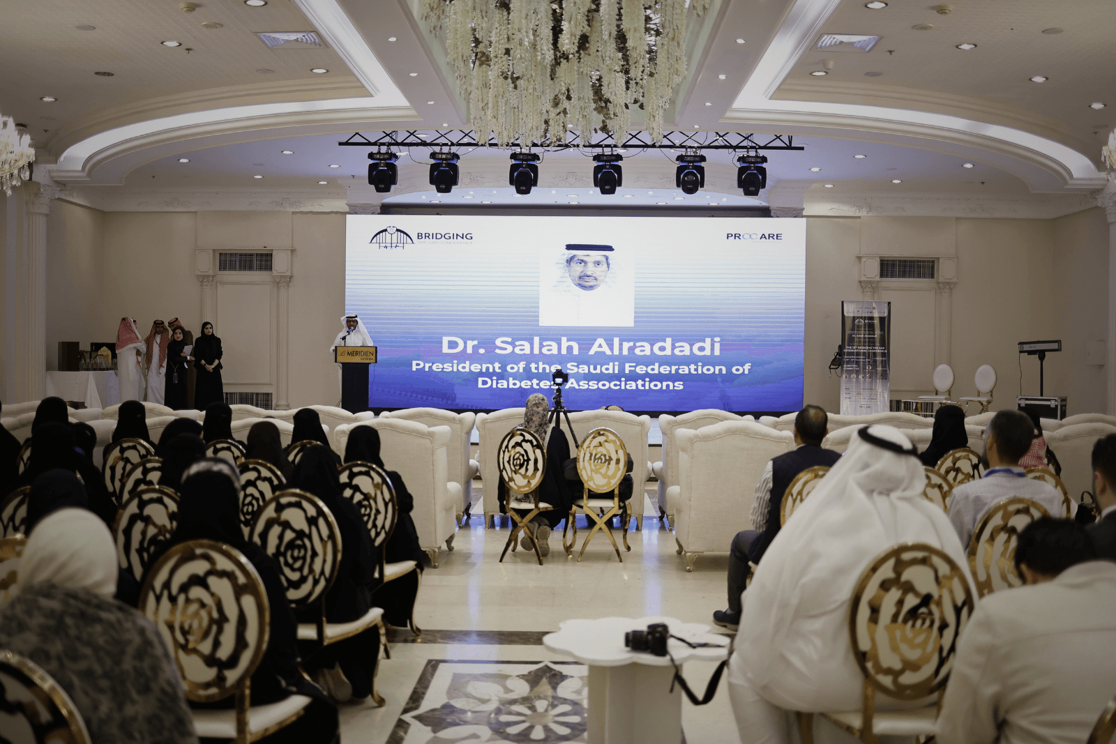 A speaker at the lectern presenting a study on clinical pharmacists' interventions in diabetes care
